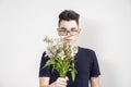 Serious young man in glasses with a bouquet of white flowers Royalty Free Stock Photo