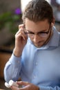 Serious young man with glasses and wireless headphones. Royalty Free Stock Photo