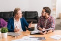 Serious young man listening to his senior colleague Royalty Free Stock Photo