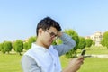 Serious young man outdoor with mobile phone. Royalty Free Stock Photo