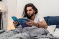 Serious young man reading about stars and destiny Royalty Free Stock Photo