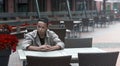 Serious young man sitting at a table in a cafe Royalty Free Stock Photo