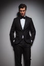 Serious young man wearing tuxedo standing with hands in pockets Royalty Free Stock Photo