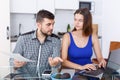 Serious young man and woman with financial documents near laptop Royalty Free Stock Photo