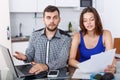 Serious young man and woman with financial documents near laptop Royalty Free Stock Photo