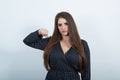 Serious young woman in black dress with white polka dot, keeping fist at camera. Royalty Free Stock Photo