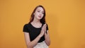 Serious young woman in black shirt claps her hands, happy