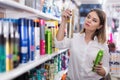 Serious young woman choosing hair care products Royalty Free Stock Photo