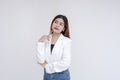 A serious young woman in deep thought while holding a pen towards her chin. Isolated on a white background Royalty Free Stock Photo