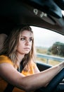 A serious young woman is driving a car wearing a seat belt and looking at the road Royalty Free Stock Photo