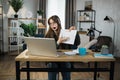 Serious young woman in headset having video conference on laptop while working from home. Royalty Free Stock Photo