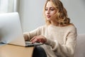 Serious young woman indoors using laptop computer Royalty Free Stock Photo