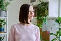 Serious young woman looking out the window, in home interior Royalty Free Stock Photo