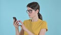 The Serious Young Woman Surfing Internet on Phone on Purple Background