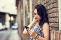 Serious young woman using her smart phone outdoors. Royalty Free Stock Photo