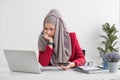 Serious young woman wearing hijab sitting at desk working on new business project alone in modern office Royalty Free Stock Photo