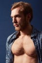 Seriously unique style. A muscular young man wearing an open shirt and looking away. Royalty Free Stock Photo