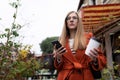 seriously, a young beautiful woman walks around the city with a cup of coffee and a phone in her hands Royalty Free Stock Photo