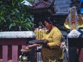 Woman With Simple Traditional Clothes Make Offerings On A Small Balinese House Shrines In A Holiday