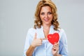 Seriuosly woman holding red heart symbol Royalty Free Stock Photo