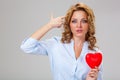 Seriuosly woman holding red heart symbol Royalty Free Stock Photo