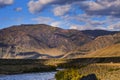 Serpentine river among the mountain peaks. Mountain lake reflects the autumn landscape of the forest with yellow leaves Royalty Free Stock Photo