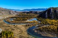 Serpentine river among the mountain peaks. Mountain lake reflects the autumn landscape of the forest with yellow leaves Royalty Free Stock Photo