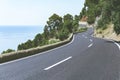 Serpentine road goes up in mountains to Mediterranean Sea in a sunny day on Mallorca island. Road travel and adventure Royalty Free Stock Photo