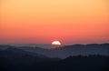 Serra da Arrabida mountain covered in greenery during an orange sunset in Portugal