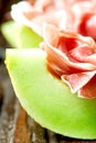 Serrano ham with melon on old wooden table vertical Royalty Free Stock Photo
