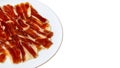 Serrano ham slices on white plate, cured meat appetizer Royalty Free Stock Photo