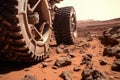 a serrated wheel of a rover on the rocky martian terrain