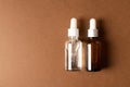 Serum bottles natural organic cosmetic with green leaf on brown