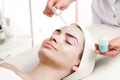 Serum facial treatment of young woman in spa salon