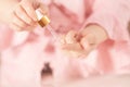 Serum in female hands, a girl in a bathroom with a pipette of essence,anti aging,cosmetics for face