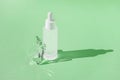 Serum skincare product with collagen and peptide in white bottle with dropper on green backdrop with crystal glass prism