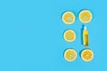 Serum in a transparent bottle with a pipette with yellow sliced lemons on blue background. Royalty Free Stock Photo