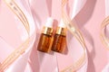 Serum in two glass bottle with pipette and pink ribbons, essential oil cosmetic flat lay, mockup. Skin care, moisturizing beauty Royalty Free Stock Photo