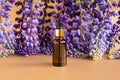 Serum in unbranded brown glass bottle with pipette and blue purple lupine flowers on brown golden background. Cosmetic bottle