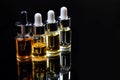 serums in glass droppers on reflective black base Royalty Free Stock Photo