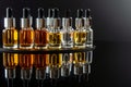 serums in glass droppers on reflective black base Royalty Free Stock Photo