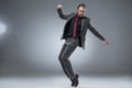 Seruous businessman in glasses in formal suit about to jump with hands outstretched while looking down, Royalty Free Stock Photo