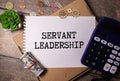 Servant Leadership write on paperwork isolated on Wooden Table