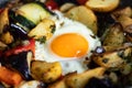 Serve one fried egg with baked vegetables, sausage. Round bright yellow yolk in the center Royalty Free Stock Photo