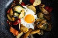 Serve one fried egg with baked vegetables, sausage. Round bright yellow yolk in the center