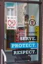 Serve Protect Respect police poster in a police station window.