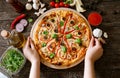 Serve traditional tasty pizza on wooden table