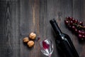 Serve wine. Bottle, glass, nuts and grape on wooden table background top view copyspace