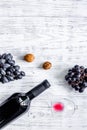 Serve wine. Bottle, glass, nuts and grape on wooden table background top view copyspace