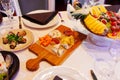 Served banquet table. Wooden board with cheese platter in the center. Royalty Free Stock Photo